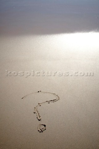 Question mark sign writing message on a sandy beach in Tarifa Spain near Gibraltar