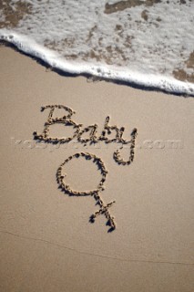 Baby girl sign writing message on a sandy beach in Tarifa, Spain, near Gibraltar.