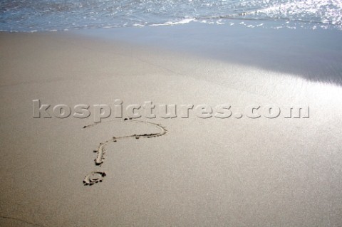 Question mark sign writing message on a sandy beach in Tarifa Spain near Gibraltar