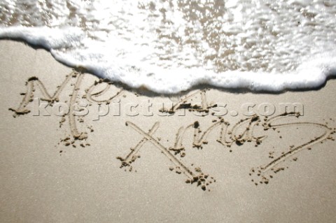 Merry Christmas Xmas sign writing message on a sandy beach in Tarifa Spain near Gibraltar