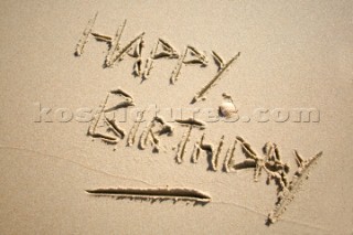Happy Birthday sign writing message on a sandy beach in Tarifa, Spain, near Gibraltar.