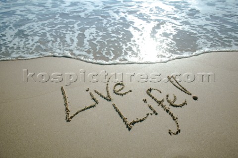 One Life  Live it sign writing message on a sandy beach in Tarifa Spain near Gibraltar