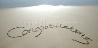 Congratulations sign writing message on a sandy beach in Tarifa, Spain, near Gibraltar.