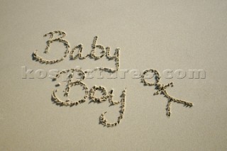 Baby boy congratulations sign writing message on a sandy beach in Tarifa, Spain, near Gibraltar.