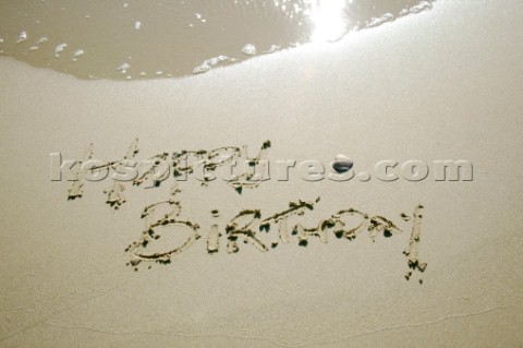 Happy Birthday sign writing message on a sandy beach in Tarifa Spain near Gibraltar