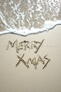 Merry Christmas Xmas sign writing message on a sandy beach in Tarifa, Spain, near Gibraltar.