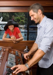 Lifestyle couple helming onboard a Vicem 72 classic motor yacht Model Released.