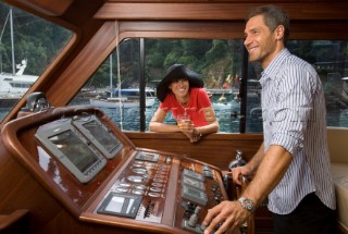 Lifestyle couple helming onboard a Vicem 72 classic motor yacht Model Released.