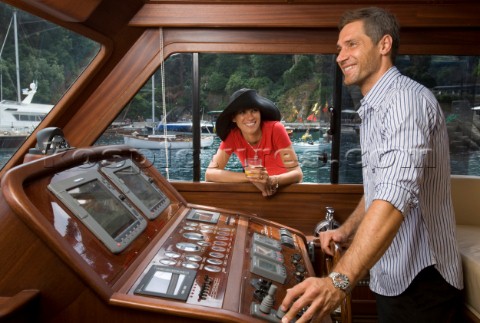 Lifestyle couple helming onboard a Vicem 72 classic motor yacht Model Released