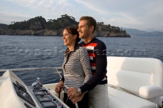 Lifestyle couple driving and helming onboard a Vicem 72 classic motor yacht Model Released.