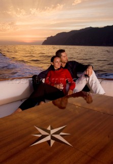 Lifestyle couple onboard a Vicem 72 classic motor yacht in the sunset Model Released.