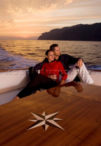 Lifestyle couple onboard a Vicem 72 classic motor yacht in the sunset Model Released