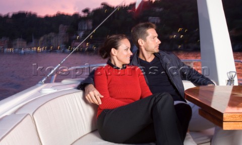 Lifestyle couple onboard a Vicem 72 classic motor yacht in the sunset Model Released