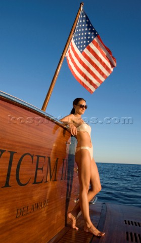 Lifestyle female onboard a Vicem 72 classic motor yacht in swimsuit on swim platform about to take a