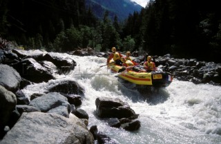 White water rafting down rapids in Austrian mountains