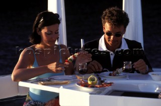 Couples enjoying a meal on deck of a Fairline powerboat