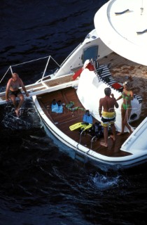 Couples on swimming platform at stern of Fairline powerboat