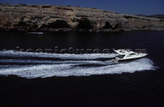 A Fairline powerboat speeds through the water leaving wash