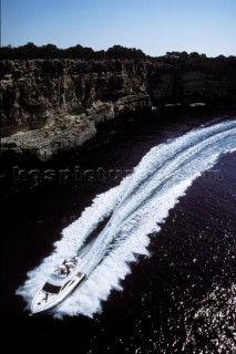 A Fairline powerboat speeds through the water leaving wash