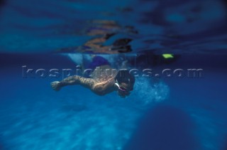 Man snorkelling in clear blue shallow water