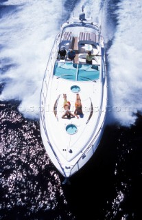 Two girls sunbathing on the bow of a Fairline power boat
