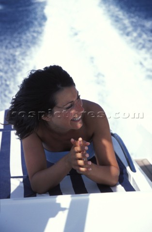 Smiling woman lying on sunlounger on Fairline powerboat