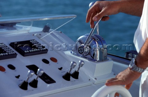 Skipper or Captains hands on the controls wheel and throttles of a motor powerboat