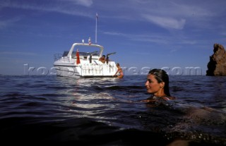 Girl swimming off anchored Fairline power boat