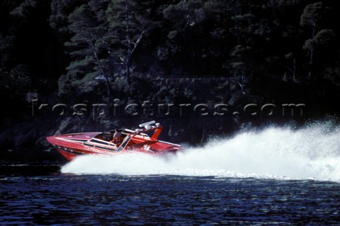Girl sunbathing on the back of a speeding powerboat with rooster tail wash