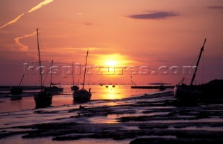 Boats on the mud at low tide at sunset