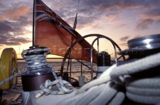 Winches and ensign flying from stern of sailing yacht