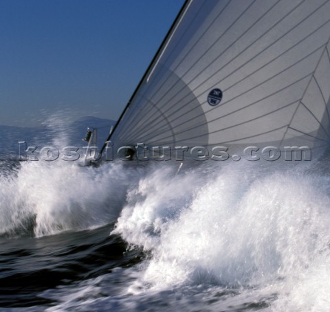 Bow of maxi yacht with North Sails logo in crashing wave