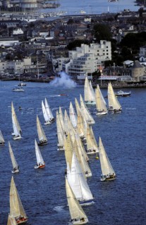 Fleet of yachts cross the start line off the Royal Yacht Squadron, Cowes, Isle of Wight