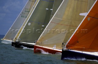 A fleet of yachts lined up to cross the start line