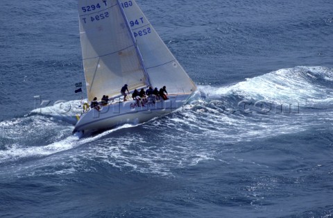Racing yacht crashing through choppy waves in the Solent UK