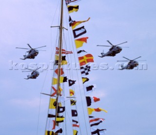 Naval helicopters flying over a yacht dressed in colours at the Trafalgar 200 celebrations in 2005
