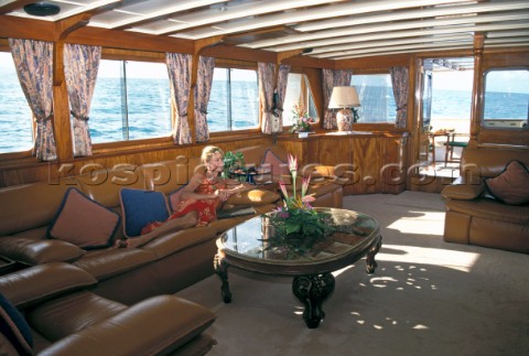 Model Jilly Johnson relaxing in the interior saloon of superyacht Antilles