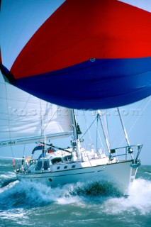 Close up of cruising  yacht under spinnaker in strong breeze