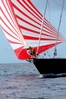 A couple on the bow of a cruising yacht under spinnaker