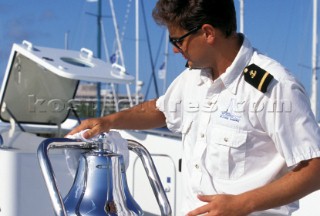 Superyacht crew member polishing ships bell