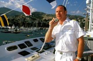 Yacht captain using VHF radio on flybridge of superyacht