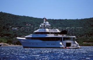 Superyacht at anchor with a Jet Ranger helicopter on the aft deck