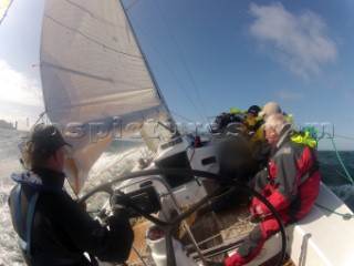 Helmsman driving upwind in rough seas onboard the Norwegian J133 Madjus during the JP Morgan Round the Island Race 2012 by The Needles