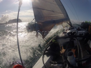 Helmsman driving upwind in rough seas onboard the Norwegian J133 Madjus during the JP Morgan Round the Island Race 2012 by The Needles