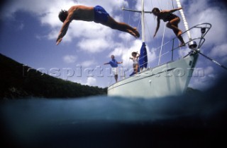 Children diving off a sailboat