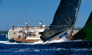The helmsman onboard the original Wally yacht Genie-of-the-Lamp fights to maintain control of the 77 foot vessel is she powers along on a spinnaker reach during a regatta in Porto Cervo, Sardinia, in the Mediterranean. Keeping a powerful racing yacht on the limit of performance and control takes years of experience and precise judgement, with helmsman and sail trimmers working in unison to power and depower the sails in phase with the gusts in the wind. With the yacht heeled at such an extreme angle, the rudder is working close to the water surface and starting to stall, reducing its efficiency. The yacht naturally wants to spin into the wind â€“ a â€˜broachâ€™. Two people are required to turn the heavy wheel and the trimmer of the large mainsail eases the mainsheet at the back of the yacht to help them turn her away from the wind. Maxi Yacht Rolex Cup 2001. Porto Cervo, Sardinia.