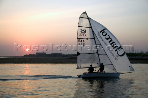 RS800 dinghy sailing under asymmetric spinnaker at sunset on the Hamble River UK