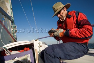 Male navigator using GPS to sail in a yacht race Round the Island Race on a J80 sportsboat
