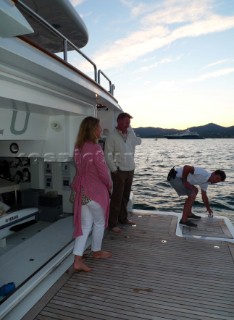 Crew prepare for tender to arrive with guests at the stern of a motoryacht superyacht in the Mediterranean