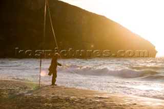Fisherman with fishing rod on the beach